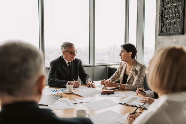 Réunion stratégique entre dirigeants et partenaires financiers d'une entreprise en croissance dans un bureau moderne